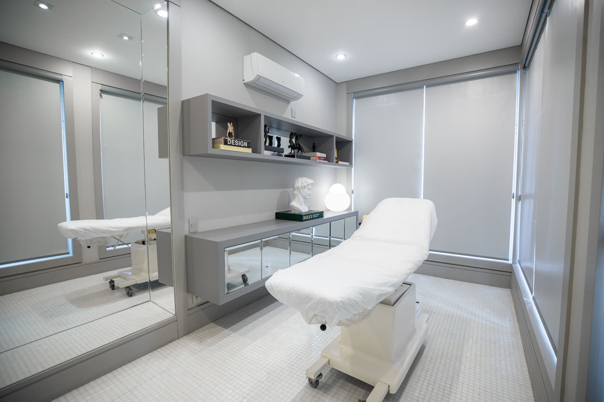 Sala de avaliação clínica com maca, espelho e iluminação natural